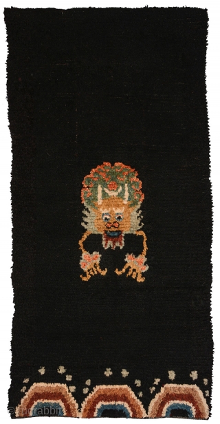 Tibetan three paneled black tsuktruk with a Zeepa (Dzeepa, Zeepak, et al) as the sole central motif, and with spray coming off a wave-like design set across the bottom. These blanket-like rugs are  ...