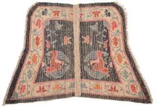 Beautiful 'butterfly' shaped under-saddle carpet from Tibet. The outer main border is of interlinked floral trellis work and has a peacock roundel as the main center field motif, which itself is a  ...