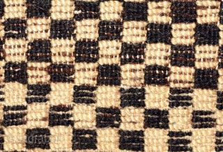 Tibetan 'butterfly-shaped' checkered makden, or under-saddle carpet. Black and white checkered center field, thin blue inner border, narrow black outer border. Circa 1920 with cotton warp and wool weft.  Size is;  ...