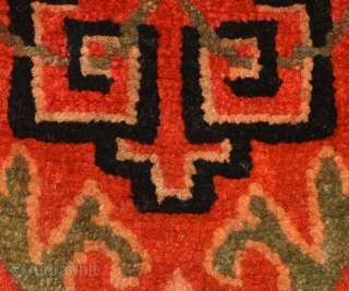 Tibetan takyeb (pack animal forehead ‘decoration’) with a geometric design and the green stems of several flowers interwoven lattice-like though it. Hand spun wool warp and weft and very tightly woven (estimated  ...