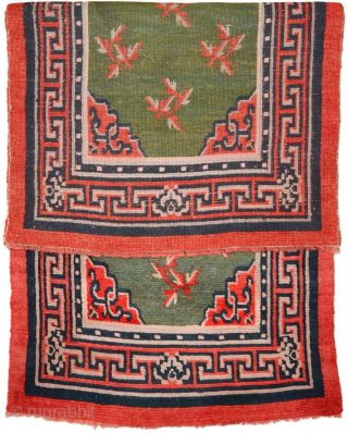Tibetan khaden with a central mandala-like motif and leaves spread sparingly throughout a subtly abrashed marled-green main field. The main border is the interlocking T design highlighted with flowers at the cardinal  ...
