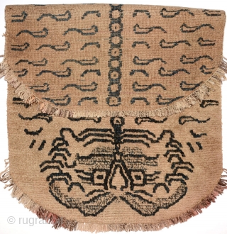 Impressive Tibetan masho or 'above-saddle' carpet portraying a tiger pelt, with a benign, almost 'pussy-cat' like face. The very light brown wool is un-dyed, while the tiger pelt design itself, which at  ...