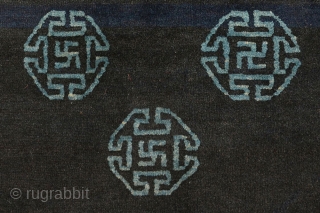 Very attractive Tibetan blue seating carpet with seven small mandala-like ‘medallions’ floating in the main field, each enclosing an auspicious swastika or sauswastika (i.e. a reverse swastika), with a 'T' shaped meander  ...