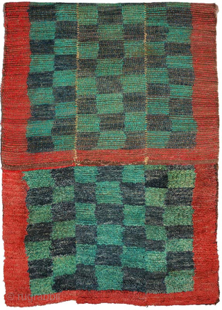 Tibetan three panelled checkered tsuktruk, abrashed throughout, the checkered pile center is of alternating blue-green and dark blue 'squares' which are surrounded by a red pile border that mimics the red covered ...