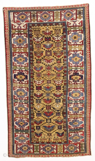 antique mustard yellow ground caucasian rug in good condition. Serrated lattice with large tulip palmettes and an unusually colorful wide ivory kufic main border. Overall nice even medium pile with slight brown  ...