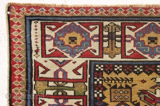 antique mustard yellow ground caucasian rug in good condition. Serrated lattice with large tulip palmettes and an unusually colorful wide ivory kufic main border. Overall nice even medium pile with slight brown  ...