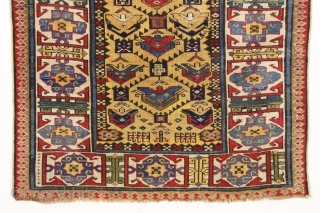 antique mustard yellow ground caucasian rug in good condition. Serrated lattice with large tulip palmettes and an unusually colorful wide ivory kufic main border. Overall nice even medium pile with slight brown  ...