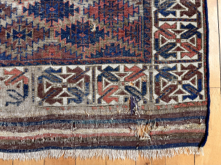 Antique Turkish knotted Baluch rug with an eye catching wide ivory border. Overall rough with low pile with heavy wear and substantial brown oxidation. Can’t quite put my finger on why but  ...
