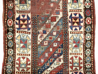 Antique Caucasian Kazak rug with interesting design features and a very unusual narrow size. The weaver altered an otherwise typical diagonal striped field with width and design changes. The extra wide ivory  ...