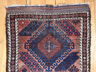 Antique small Baluch rug with some unusual features. A mini runner, rather narrow for its length. In the “mushwani” design family with its latch hooked field. An unusual border  that I  ...