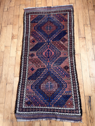 Antique small Baluch rug with some unusual features. A mini runner, rather narrow for its length. In the “mushwani” design family with its latch hooked field. An unusual border  that I  ...