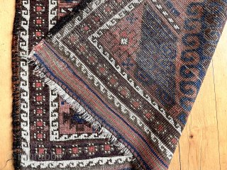 Antique small Baluch rug with some unusual features. A mini runner, rather narrow for its length. In the “mushwani” design family with its latch hooked field. An unusual border  that I  ...