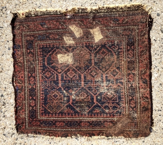 Antique little Baluch bagface with classic lattice and inset flowering plants. Better than average drawing and natural colors for this well known type. Excellent light blues and attractive reds. Unfortunately in somewhat  ...