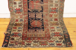 antique long rug, probably nw persian, with an interesting archaic design and older all natural colors. Note the area of white cotton pile seen clearly in back pic. In abused condition, very  ...