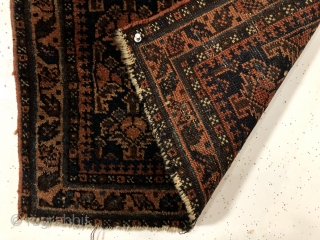 Antique blue ground Baluch bagface with an uncommon design featuring floral pendants usually associated with daktor e gazi prayer rugs. Overall good pile with a small center area of wear and two  ...