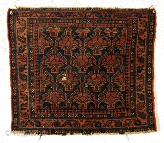 Antique blue ground Baluch bagface with an uncommon design featuring floral pendants usually associated with daktor e gazi prayer rugs. Overall good pile with a small center area of wear and two  ...