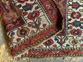 Antique northwest Persian or Kurdish rug or what remains of a rug. Has lovely old natural colors and charming drawing. I like the little border elements that look like houses. Lots of  ...