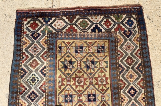 Early yellow ground Caucasian long rug with some unusual design features and excellent saturated natural colors. Kazak? Gendge? Eye catching uncommon ivory border. Unfortunately damaged with a large tear as shown. As  ...