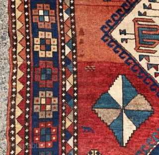 Antique large Kazak rug in fair condition with classic ivory Lori Pombak medallions. Good original natural colors with an abrashed tomato red ground and both light and dark blues. Overall good even  ...