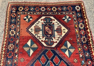 Antique large Kazak rug in fair condition with classic ivory Lori Pombak medallions. Good original natural colors with an abrashed tomato red ground and both light and dark blues. Overall good even  ...