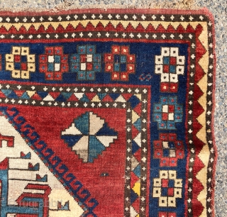 Antique large Kazak rug in fair condition with classic ivory Lori Pombak medallions. Good original natural colors with an abrashed tomato red ground and both light and dark blues. Overall good even  ...