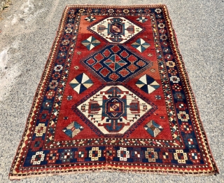 Antique large Kazak rug in fair condition with classic ivory Lori Pombak medallions. Good original natural colors with an abrashed tomato red ground and both light and dark blues. Overall good even  ...