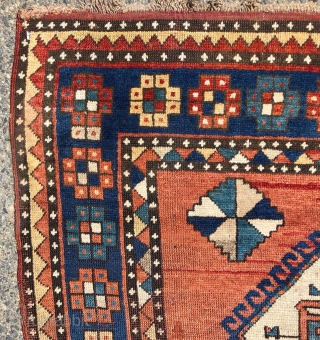 Antique large Kazak rug in fair condition with classic ivory Lori Pombak medallions. Good original natural colors with an abrashed tomato red ground and both light and dark blues. Overall good even  ...