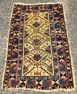 Antique yellow ground Caucasian rug, probably Avar, with a spacious lattice of large tulip palmettes. Overall even very low pile with scattered wear as shown. Small edge tear and a spot or  ...