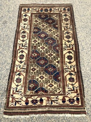 Antique Baluch rug with large scale Memling guls on a soft honey colored ground. Spaciously drawn older type border. Overall fair condition for an older piece with mostly good even pile. Moderately  ...