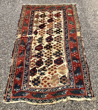 Antique Caucasian ivory ground rug with an eye catch design of very colorful large boteh and a marasali type border with “chessmen”  or bird motifs. Mostly decent low pile but scattered  ...