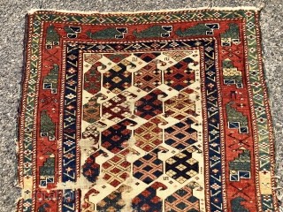 Antique Caucasian ivory ground rug with an eye catch design of very colorful large boteh and a marasali type border with “chessmen”  or bird motifs. Mostly decent low pile but scattered  ...