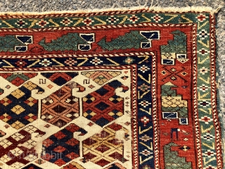 Antique Caucasian ivory ground rug with an eye catch design of very colorful large boteh and a marasali type border with “chessmen”  or bird motifs. Mostly decent low pile but scattered  ...