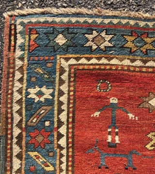 Antique small Kazak rug in good untouched condition with spacious drawing featuring charming large stylized humans. All natural colors including an attractive tomato red ground, sky blue border and an unusual lovely  ...