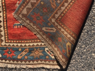 Antique small Kazak rug in good untouched condition with spacious drawing featuring charming large stylized humans. All natural colors including an attractive tomato red ground, sky blue border and an unusual lovely  ...