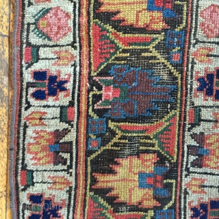 Early large northwest Persian rug. Eye catching archaic border. Excellent all natural colors featuting lovely greens and rich old purples. As found, areas of wear, slight edge roughness, crude patch. Restorable. Storage  ...