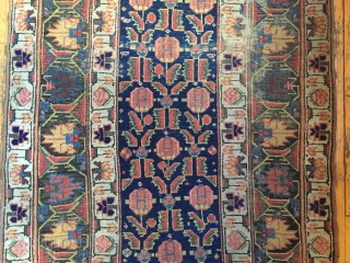 Early large northwest Persian rug. Eye catching archaic border. Excellent all natural colors featuting lovely greens and rich old purples. As found, areas of wear, slight edge roughness, crude patch. Restorable. Storage  ...