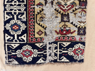 Out of the cedar chests. Early yellow ground Caucasian rug fragment. Sewn onto backing cloth. Saturated colors. Fine Kufic border. Good age. First half 19th c. Largest section 18” x 43”  