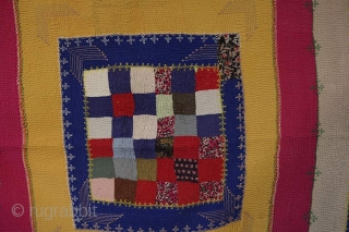 D107. Indus Valley quilt. 1960s. Coloured mill cloth, possibly rayon. Very fine coloured quilting. Added embroidery where different colours have been joined, and in other areas. Checked design at centre includes some  ...