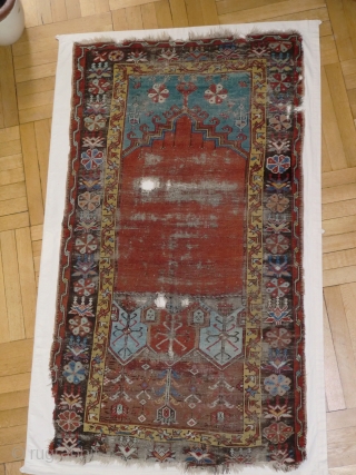 Ladik Prayer rug. Before 1800. 100x200cm, mounted on linen. The great age of this magnificient rug is confirmed, apart from the iconographics, by the colors. The deep stone-red of the 'ocak'( the  ...