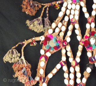 Decorative rope camel trapping, this vintage piece is embellished with shells, mirrors and tassels with a large central fringed rope pom pom.
This would be worn by placing over the head and neck  ...