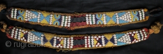 A pair of related but different antique tribal camel neck decorated bands. 

The bands incorporate a variety of materials and construction techniques. They are made using cowrie shells, hand made glass beads  ...