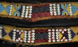 A pair of related but different antique tribal camel neck decorated bands. 

The bands incorporate a variety of materials and construction techniques. They are made using cowrie shells, hand made glass beads  ...