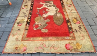 Chinese Xinjiang rug, red background with  little lion pattern, fruit veins selvage, the pronunciation of “tai Shi”, means an official position in ancient China. Good age and condition. Size 180*285cm(70*111”)  