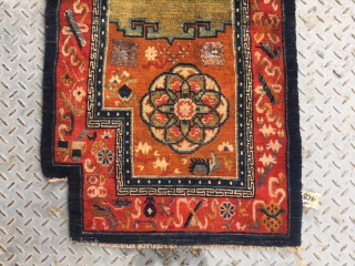 Tibetan  horse saddle rug, Orange background color with group flower pattern, Chinese traditional eight treasures selvage. Good age and condition. Size 65*138cm (25*54”)
         