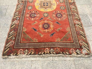 Khotan rug,  it was produced in Khotan area, red background with group flowers veins, lucky clouds sell. About 1920. It has a little wool pile worn. Size 135*245cm(53*96”)    