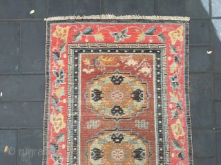 Tibet rug, camel background with three group flowers pattern, around red color full flower selvage. Size 152*83cm(59*32”) wool warp and weft. Good age          