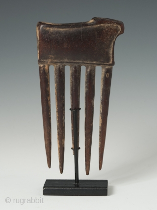 Charming carved wood comb from the Baule tribe, Côte d'Ivoire, depicting an animal. 5" (12.6 cm) high                