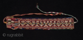 Headband, Bolivia. 16" by 3". Wool, beads. Mid 20th century. Condors, fish and various four-legged beasts are woven into this headband, which is bordered by loops of colorful beads. In good condition,  ...