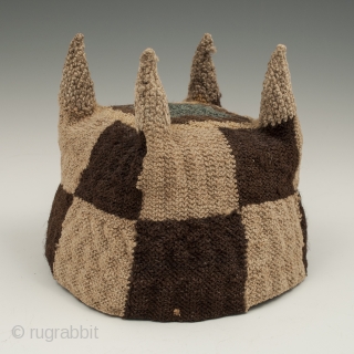 Four-cornered hat, Huari culture, Peru. Camelid fibers, natural dye.
A.D. 700-1000, 5.25" (13.3 cm) high by 5.75" (14.6 cm) diameter.
Ex. Fifi White collection, California. 	

An unusual brown and tan checkerboard four-cornered hat with  ...