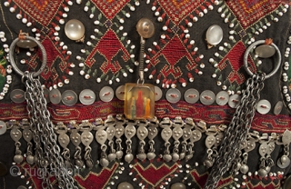 A very special child's vest from the Kohistan area of Pakistan. It is finely embroidered and extravagantly decorated with beads, buttons, and silver ornaments. There is a charming whistle on the front,  ...